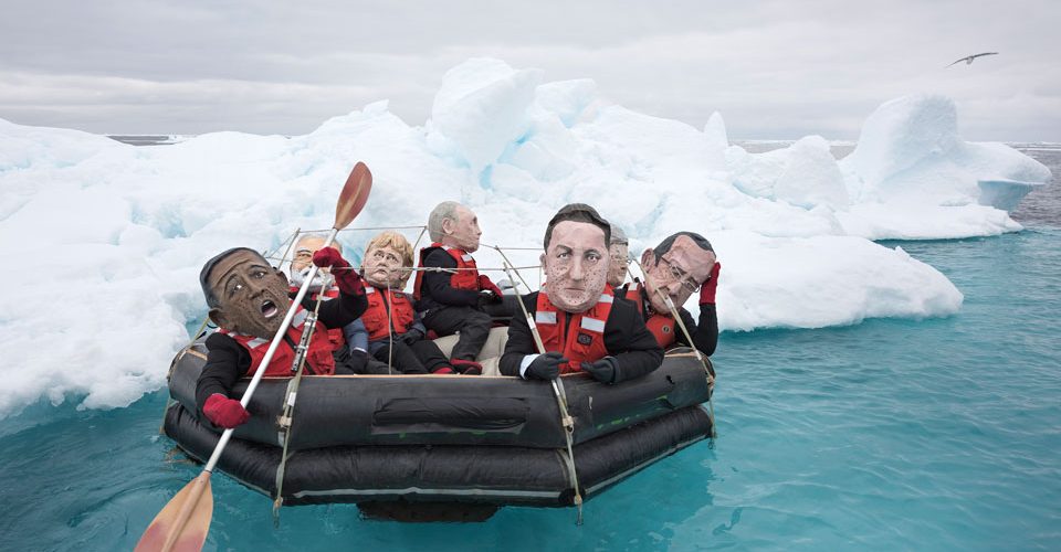 Activists in papier-mâché world leaders' heads flounder in the Arctic Ocean.